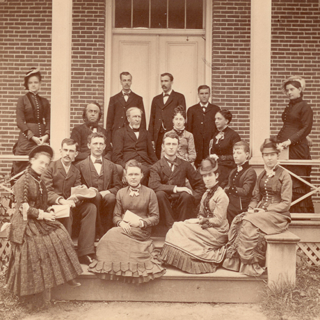 sepia image of men and women seated on porch