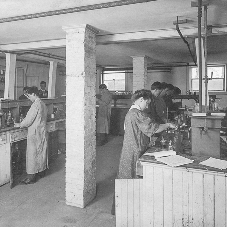 historical photograph of men and women working in lab