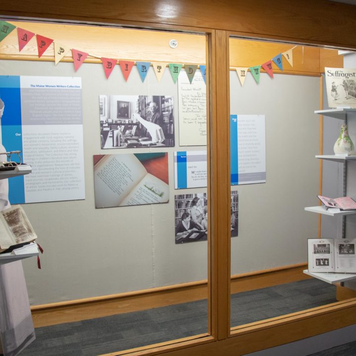 Exhibit case in Abplanalp Library featuring photos and objects from Maine Women Writers Collection