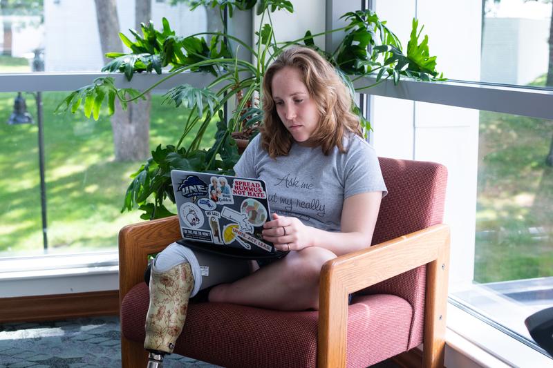 Student sitting in lounge chair studying on laptop.