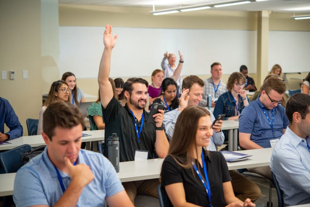 students in classroom with man raising hand